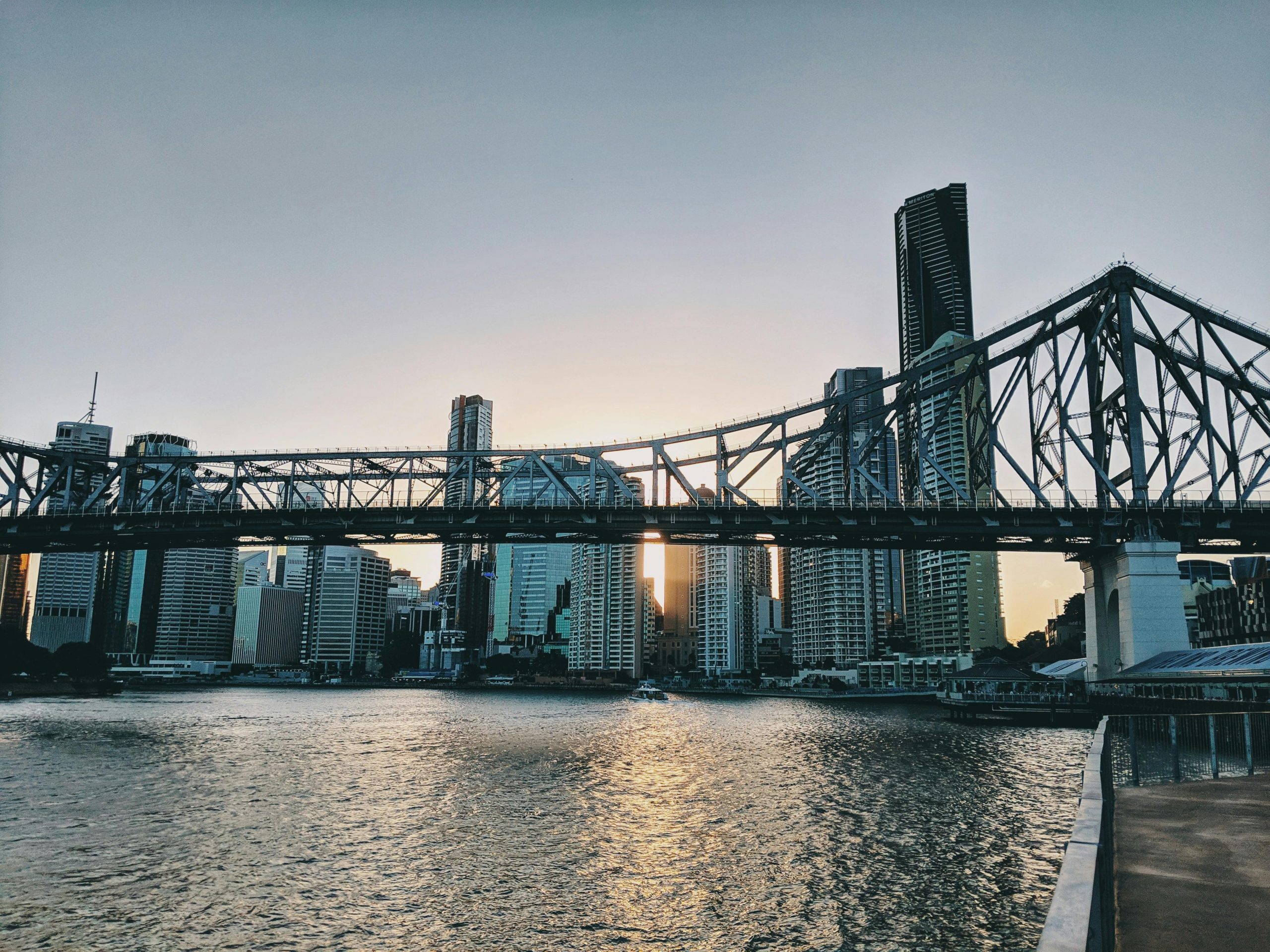 Stunning view of Brisbane's skyline and Story Bridge at dusk with water reflections.